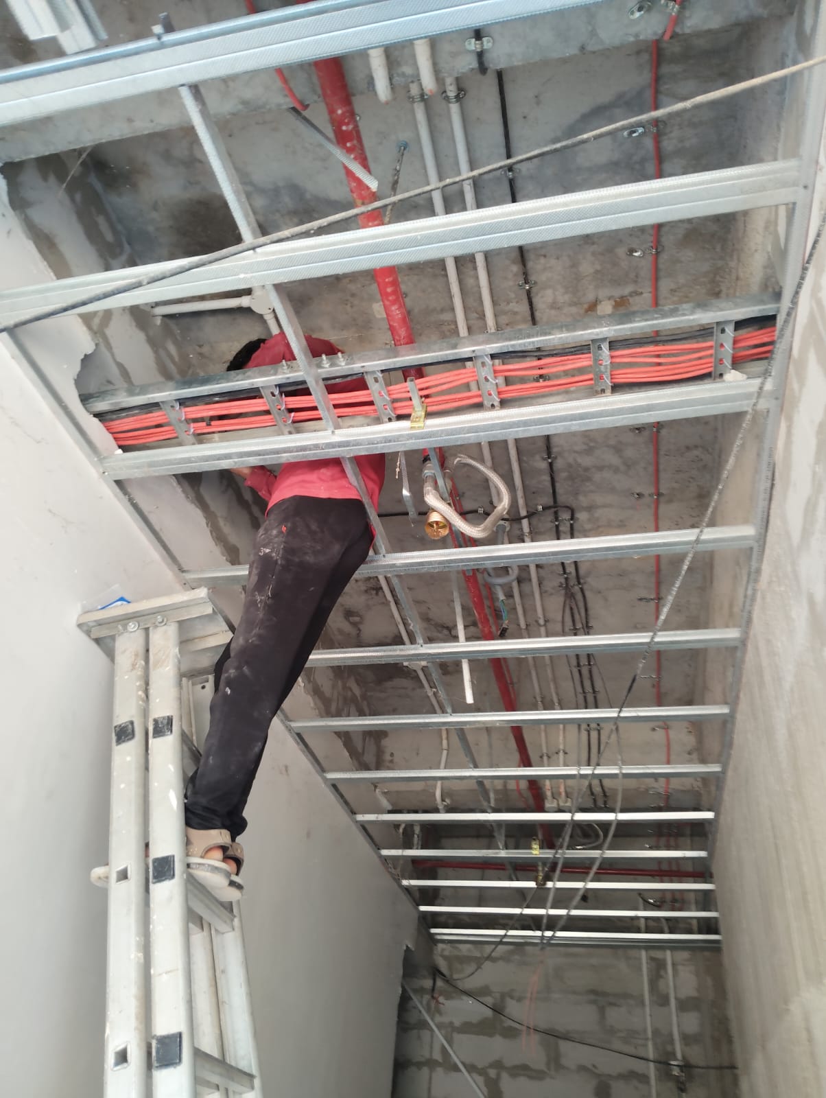 Red fire alarm cables routed and secured in metal cable tray
